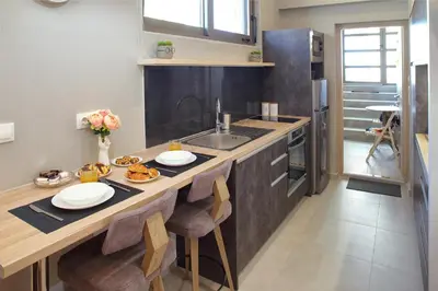a kitchen with a large wooden island with a sink at Mirma Halepa superior studio in Chania Town