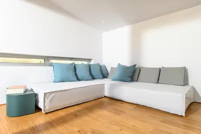 a white couch with blue pillows in a room at Artful City Loft with Rooftop Terrace, Near Beach in Chania Town