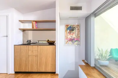 a kitchen with white walls and a wooden cabinet at Artful City Loft with Rooftop Terrace, Near Beach in Chania Town