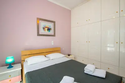 a bedroom with a large bed with white cabinets at Eleni Residence by the sea in Ropanianá