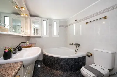 a bathroom with a tub and a toilet and a sink at Eleni Residence by the sea in Ropanianá