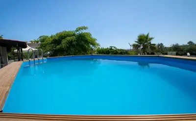 a large swimming pool with blue water at Eleni Residence by the sea in Ropanianá