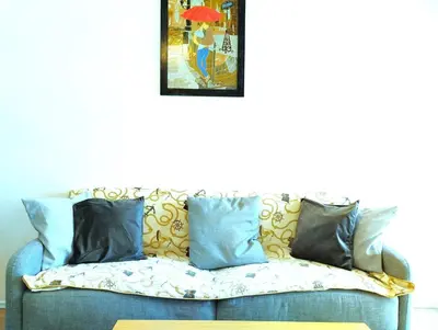 a blue couch with pillows and a picture on the wall at Apartment - Sleeps 4 & Free Parking in Chania Town