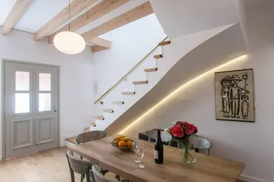 a dining room with a wooden table and stairs at House of Sirri in Chania Town