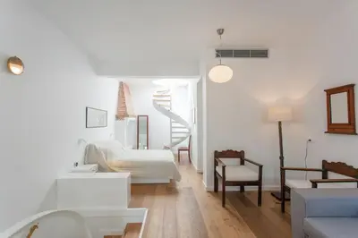 a living room with white furniture and a staircase at House of Sirri in Chania Town