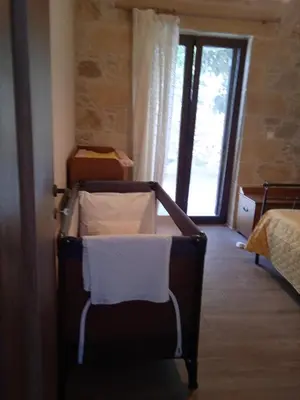 a room with a bed and a window and a chair at Fanouria's home in Kalleryianá