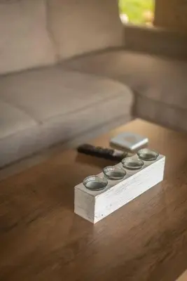 a wooden table with three remote controls and a cell phone at Fanouria's home in Kalleryianá