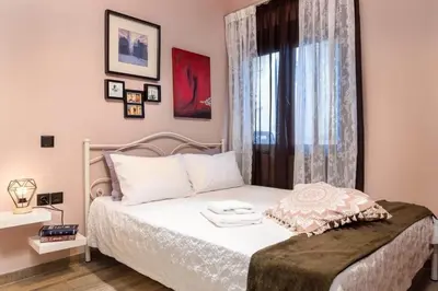 a bedroom with a white bed with a window at Eva Cozy Apartment in Chania Town