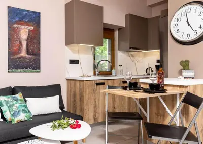 a living room and kitchen with a clock on the wall at Eva Cozy Apartment in Chania Town