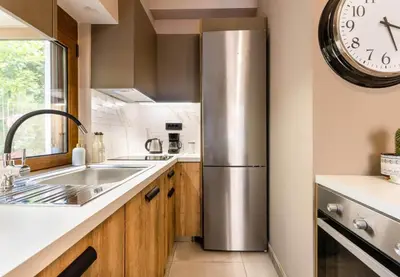 a kitchen with a stainless steel refrigerator and a clock at Eva Cozy Apartment in Chania Town