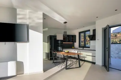 a kitchen and dining room with a table and chairs at Villa Kafkales Maleme - Heated Pool in Maleme