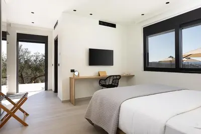 a bedroom with a bed and a desk with a tv at Villa Kafkales Maleme - Heated Pool in Maleme