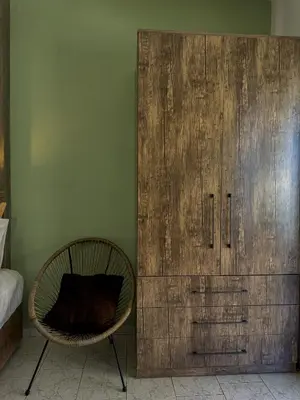 a room with a chair and a wooden cabinet at Kydonia apartments in Plataniás