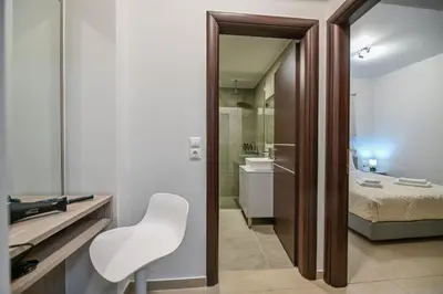 a room with a white chair and a bathroom at A & G Apartments in Kolymvari
