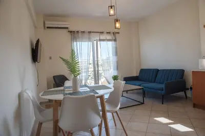a living room with a table and a blue couch at Kds Overlooking Chania in Chania Town