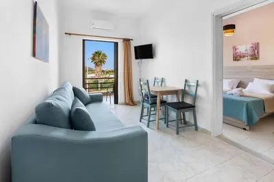 a living room with a blue couch and a bedroom at Sun Beach Apartments in Chania 09 11 in Chania Town