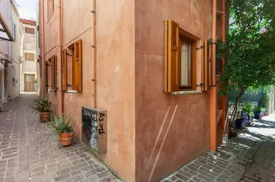 a building with windows and plants on a street at Cozy house in the old town in Chania Town