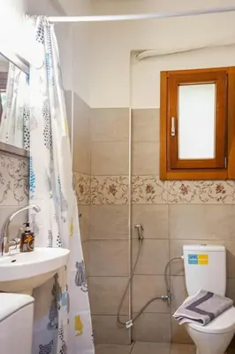 a bathroom with a shower and a toilet and a sink at Cozy house in the old town in Chania Town