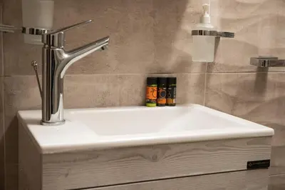 a bathroom sink with a faucet and some spices at Harmony Apartment in Chania in Chania Town