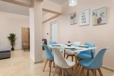 a dining room with a table and blue chairs at Harmony Apartment in Chania in Chania Town