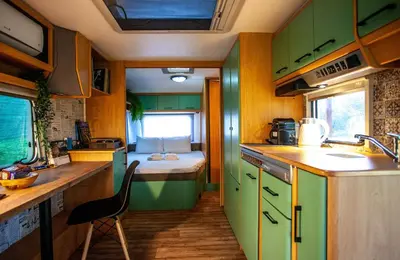 a kitchen with green cabinets and a bed in a room at Onar Camper in Liyidhés