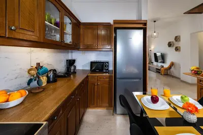 a kitchen with wooden cabinets and a stainless steel refrigerator at Central apt. with parking - 3 min from old port in Chania Town