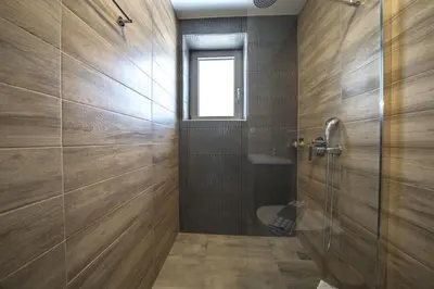 a bathroom with a shower and a glass door at Nafsika Xenia - Alkinoos Villa in Plátanos