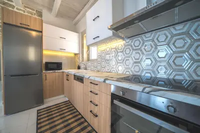 a kitchen with wooden cabinets and a stainless steel refrigerator at Nafsika Xenia - Alkinoos Villa in Plátanos