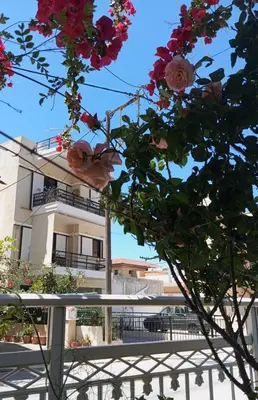 a building with flowers in front of a fence at Sunny family apartment in Chania close to the sea in Chania Town