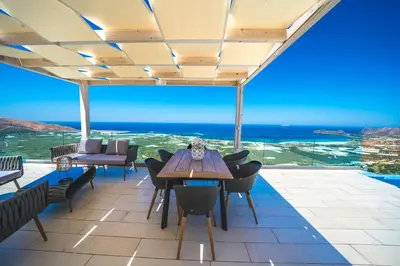 a dining room with a view of the ocean at Nafsika Xenia - Ariti Villa in Plátanos