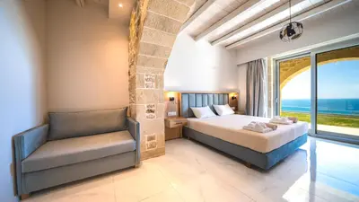 a bedroom with a bed and a couch and a window at Nafsika Xenia - Ariti Villa in Plátanos