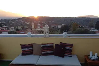 a bed on a balcony with a view of a city at Giannis Traditional House in Vamos