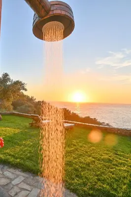 a water fountain with the sunset in the background at Metochi Seaview Holiday House in Ayía Paraskeví