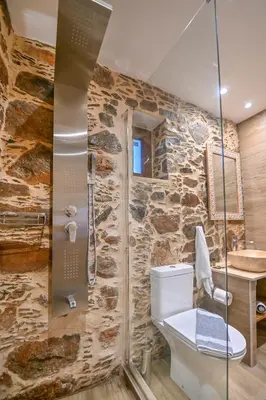 a stone bathroom with a toilet and a shower at Metochi Seaview Holiday House in Ayía Paraskeví