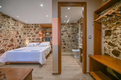 a bedroom with a large bed and a bathroom at Metochi Seaview Holiday House in Ayía Paraskeví