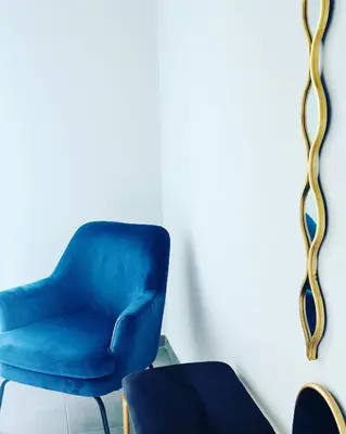 a blue chair sitting next to a mirror at Meliora Suites in Drapaniás