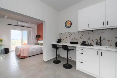a kitchen with a desk and a bed in a room at Meliora Suites in Drapaniás