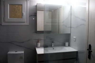 a bathroom with a sink and a mirror and a toilet at Monica's Luxury Apartment in Chania Town