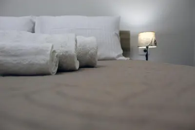 a white bed with white sheets and a lamp at Monica's Luxury Apartment in Chania Town