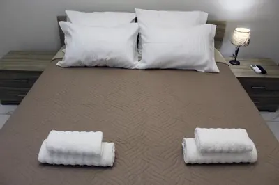 a large bed with white pillows and two white pillows at Monica's Luxury Apartment in Chania Town