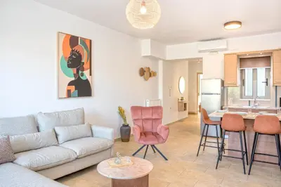 a living room with a couch and chairs and a kitchen at Casa Kamara in Kounoupidhianá