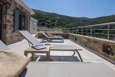 a balcony with tables and benches on a building at Vigla Apartments No.3 in AmigdhalokeFálion