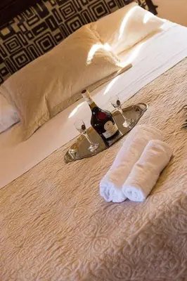 a bed with two towels and a bottle of wine at Lefteris Holiday Home in Chania Town