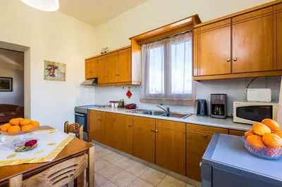 a kitchen with wooden cabinets and a bowl of oranges at Lefteris Holiday Home in Chania Town