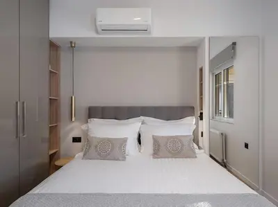 a bedroom with a large bed with white sheets and pillows at Marita Luxury Apartment with parking space in Chania Town