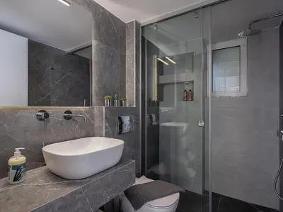 a bathroom with a sink and a glass shower at Marita Luxury Apartment with parking space in Chania Town