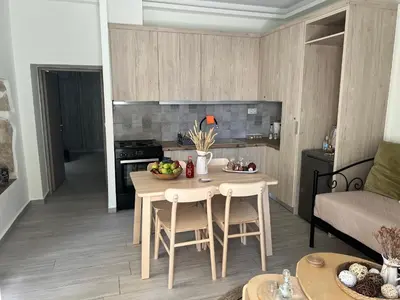 a kitchen with a table and chairs in a room at Granny's Nest in Kalyves