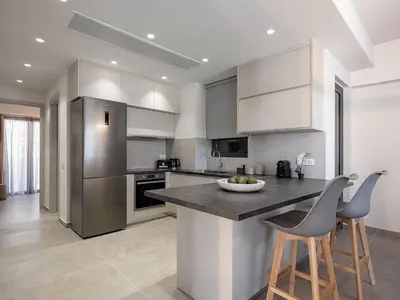 a kitchen with white cabinets and a black counter top at Casa D'Irene Apts in Chania Town