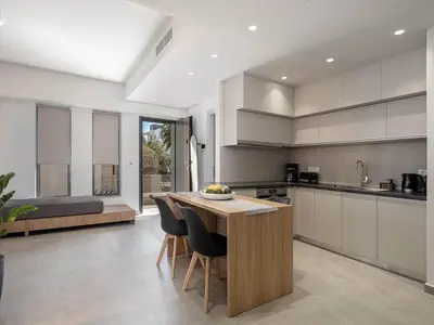 a kitchen with a table and some chairs in it at Casa D'Irene Apts in Chania Town