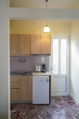 a kitchen with a white refrigerator and a sink at Cozy Corner VS Beachfront in Stalos